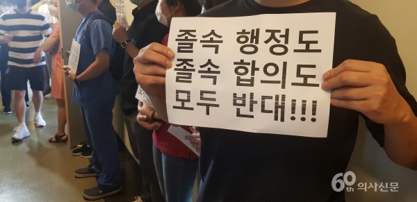 4일 복지부와 의협의 합의문 서명식이 진행된 한국건강증진개발원 24층 대회의실 앞에서 전공의들이 피켓을 들고 서 있다.